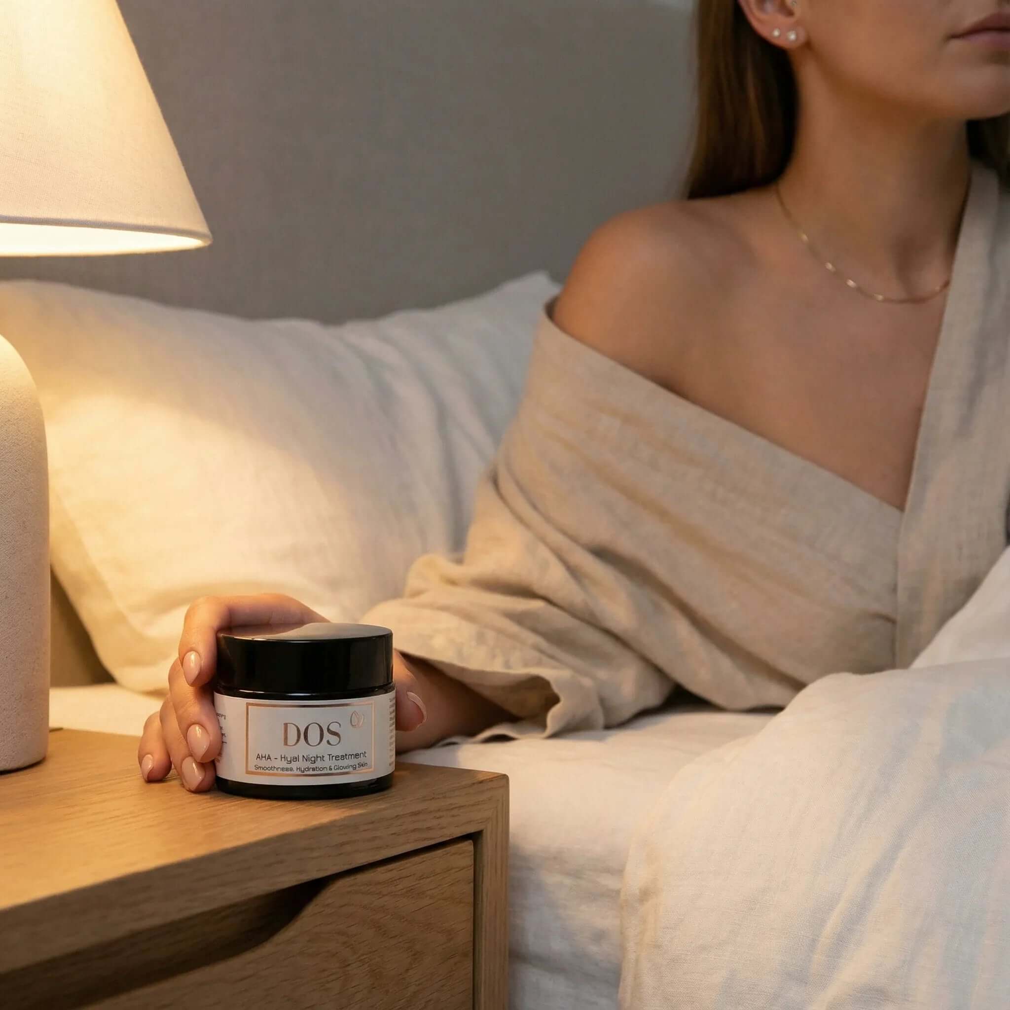 AHA night cream on a bedside table, perfect for overnight skin regeneration and hydration. DOS Cosmetics