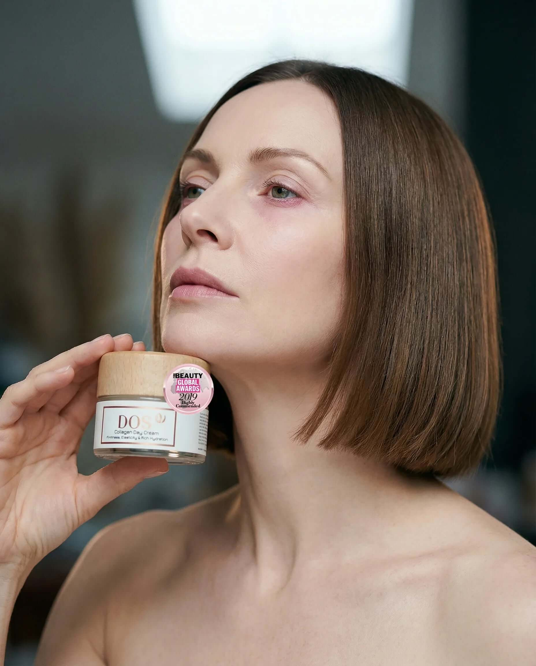 Collagen day cream held by a woman showcasing its award-winning hydration benefits for radiant skin. DOS cosmetics