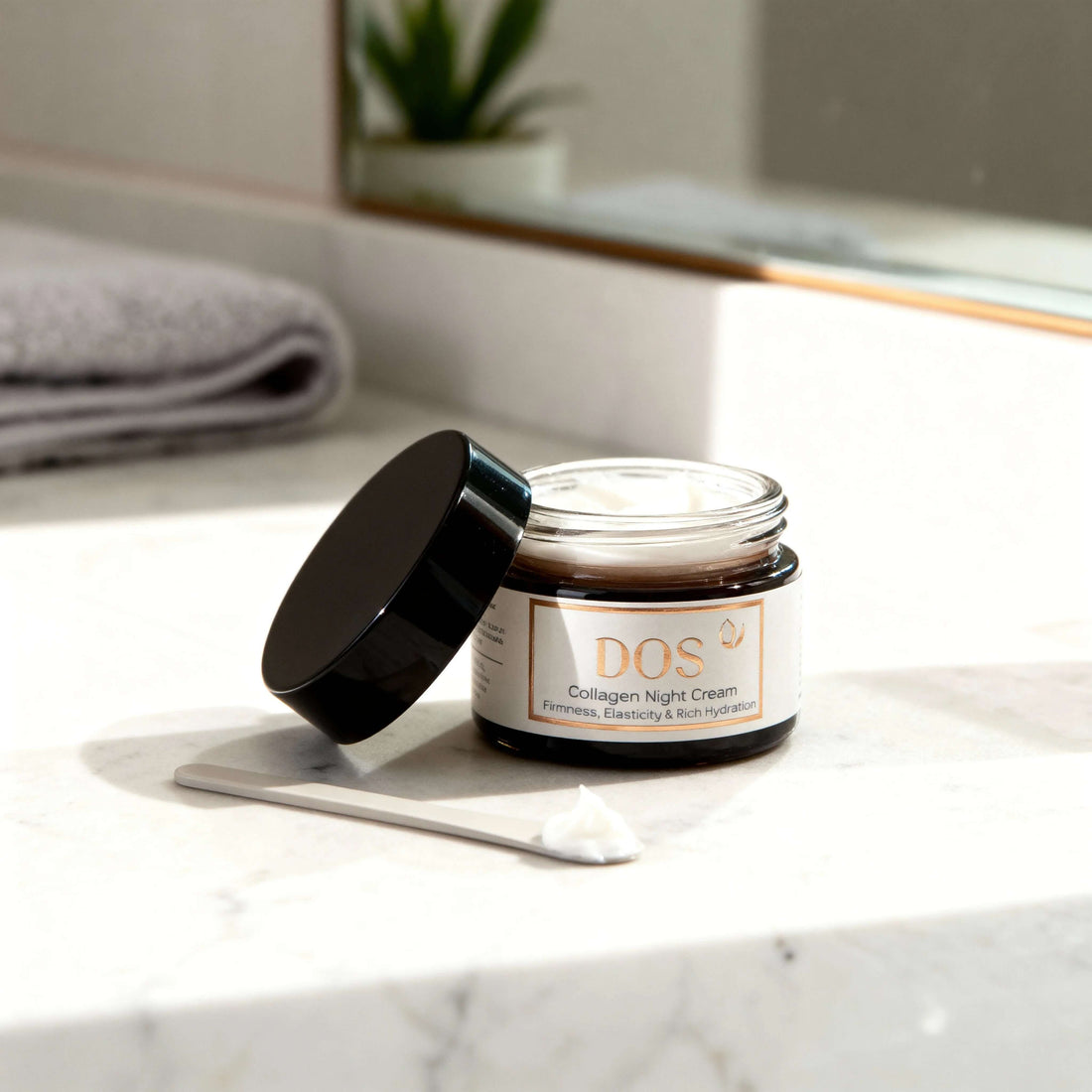Collagen night cream jar on a marble countertop, featuring firming and hydrating benefits for overnight skin renewal. DOS Cosmetics