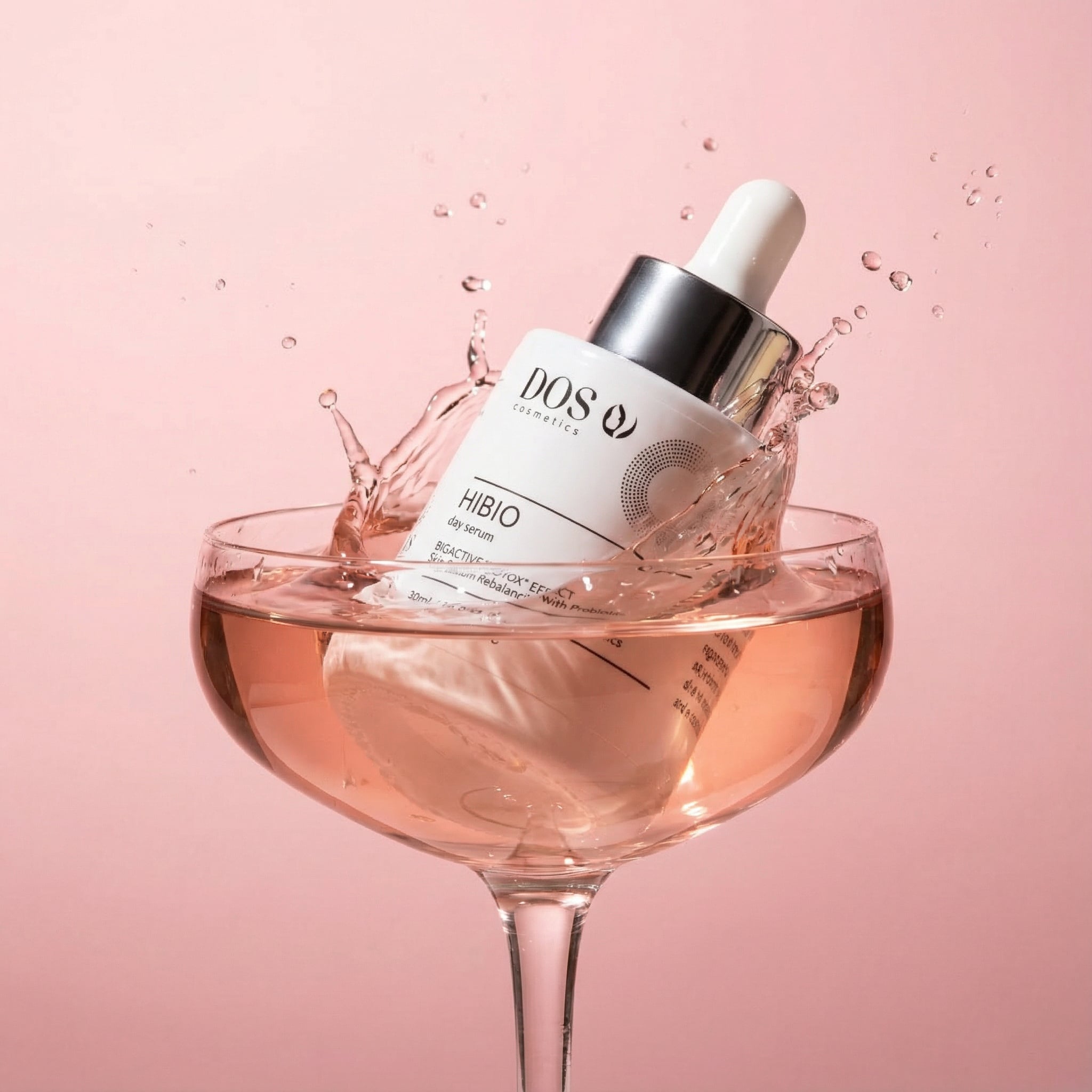 Dos Cosmetics skincare Hibio day serum with dropper in a glass of rose wine on a pink background