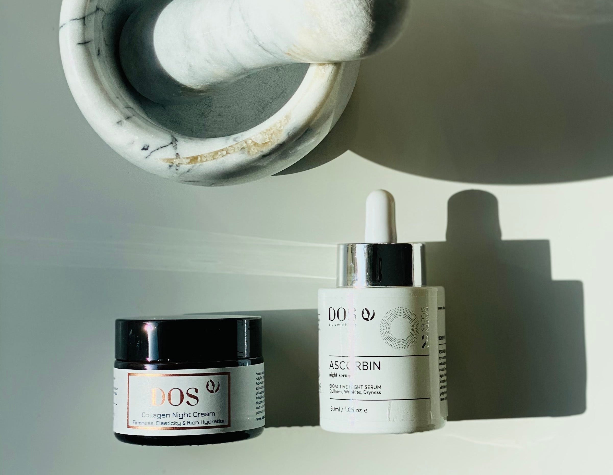 Two skincare products on a light gray background from DOS Cosmetics
