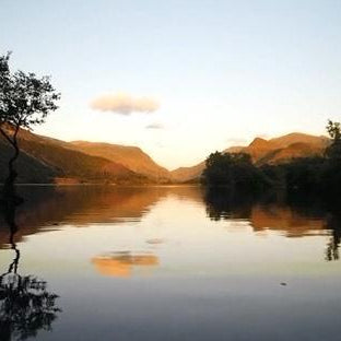 Serene landscape with a lake, trees, and mountains at sunset, inspired by ancient Greek. DOS Cosmetics