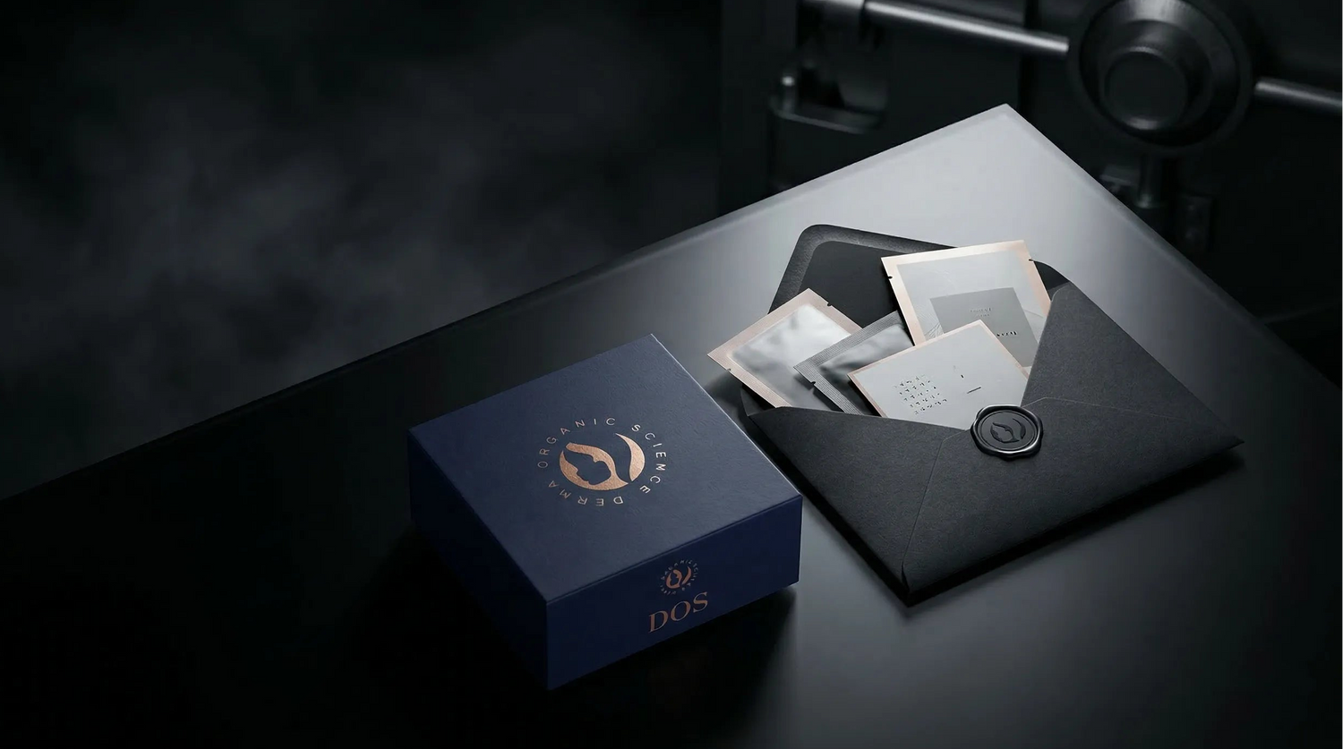 DOS Cosetics Blue box with a black envelope on a dark surface, featuring the brand.