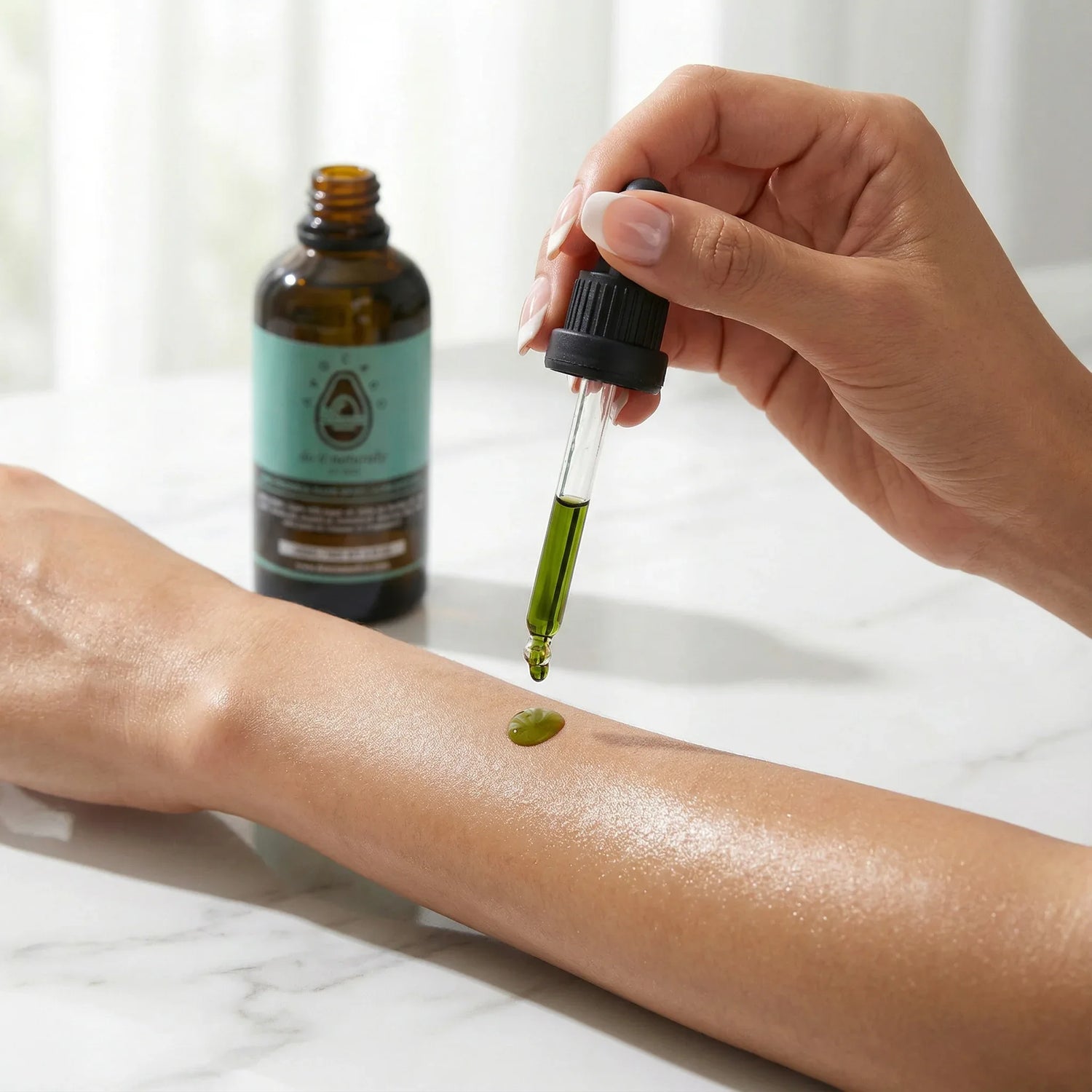 Hand applying green avocado liquid from a dropper to an arm with a bottle in the background - DOS