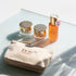 Cosmetic products including jars and a bottle on a glass surface with &